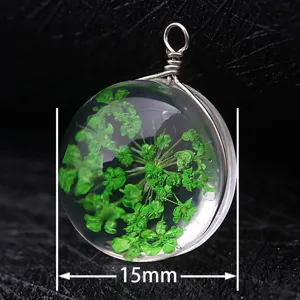 Macro detail of a 15mm round glass pendant featuring preserved green dried flowers.