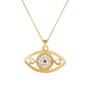 Detailopname van een gouden boze oog hanger ketting met zirkoniasteentjes en pareltjes