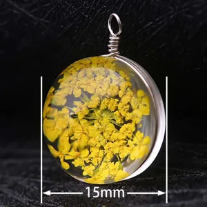 Detailed macro shot of a 15mm round glass pendant containing yellow dried flowers