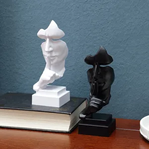 Detail view of abstract silence face resin ornament, modern desktop decor for home office.