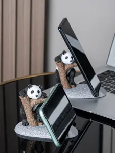 Gedetailleerde opname van schattige panda-telefoonhouders op een strak en modern bureau