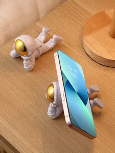 Gros plan sur le support de téléphone astronaute créatif sur bureau, jolie déco en résine.