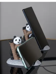 Gedetailleerde macro-opname van creatieve panda-telefoonstandaard op reflecterend oppervlak
