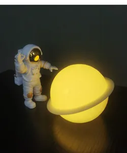 Vista detallada de la lámpara de noche planeta astronauta, luna brillante para dormitorio.