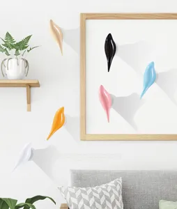 Modern bird-shaped decorative wall hooks in multiple colors mounted on a white wall