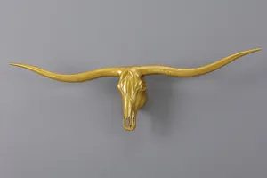 Close-up view of gold longhorn bull skull wall hanging, retro animal decor for industrial style.