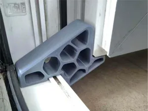 Vista detallada del tope limitador de puerta y ventana corredera gris, seguridad en el hogar.