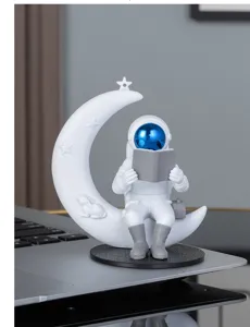 Figurine d'astronaute lisant sur la lune vue détaillée, ornement de bureau créatif en résine.