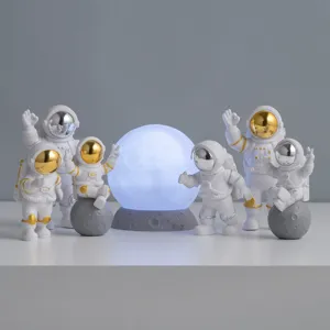 Creatief astronauten beeldjesset met gloeiende maanlamp voor decoratie in de kinderkamer.