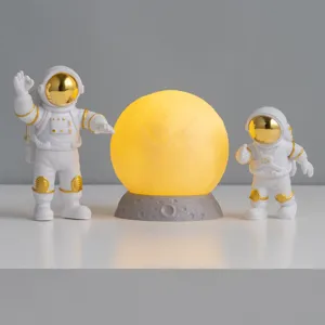 Creatief astronauten beeldjesset met gloeiend maan nachtlampje voor decoratie van de kinderkamer.