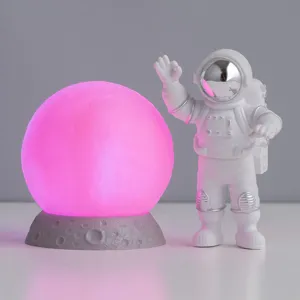 Gedetailleerd overzicht van creatieve astronaut nachtlamp met gloeiende roze maan voor decor.