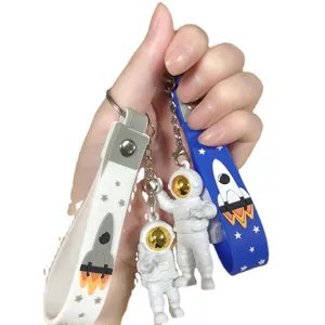 Cute astronaut keychain set with glowing gold visor and rocket pendant for backpack or keys gift.