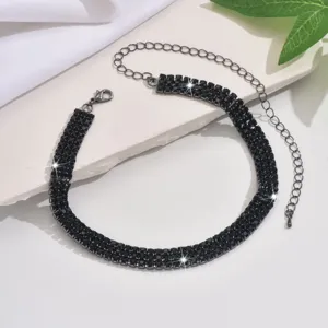Black rhinestone choker necklace detail, multi-row sparkling crystal claw chain jewelry.