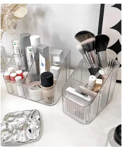 Clear acrylic desktop makeup organizer box with multiple compartments for cosmetics.