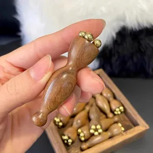 Detailansicht des hölzernen Gesichts-Massagegeräts mit Messingkugeln für die Augenakupunktur.