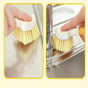 Vista detallada de un cepillo de limpieza triangular plegable para fregaderos de cocina.