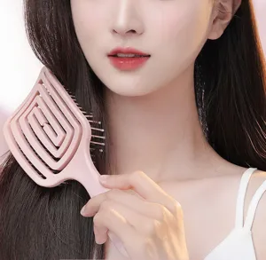 Curved hollow hairbrush detail shot, pink styling comb for smooth detangling and hair volume.