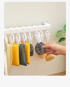 Étagère de rangement murale avec pinces pour torchons de cuisine, éponges et outils de nettoyage.