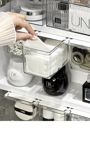 Transparent plastic drawer organizer for cotton pads and swabs, closeup detail in mirror cabinet.