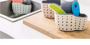 Detailed view of kitchen sink caddy sponge holder with drainage holes on wooden board display.