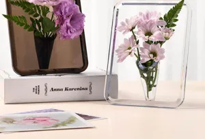 Detailansicht der Acryl-Fotorahmen-Vase mit klarem Design und rosa Blumenarrangements im Raum.