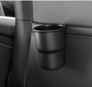 Car cup holder detail view, universal black plastic drink organizer mounted on vehicle seat back.