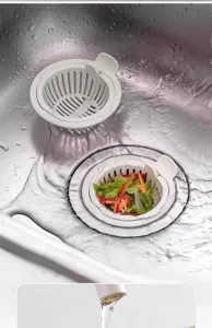 Detailed view of white plastic kitchen sink strainer basket, anti-clog design for food waste.