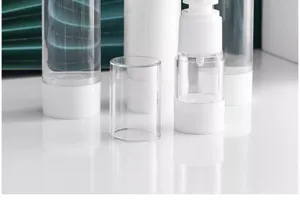 Close-up detail of clear travel cosmetic pump bottle with white base for liquid skincare.