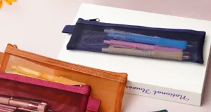 Detail shot of transparent mesh pencil case showing zipper design and colorful stationery inside.