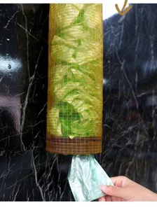Close-up detail of wall-mounted mesh grocery bag holder in kitchen, showing easy bottom pull.