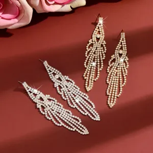 Detailed view of sparkling rhinestone tassel earrings, featuring silver and gold long crystal designs.
