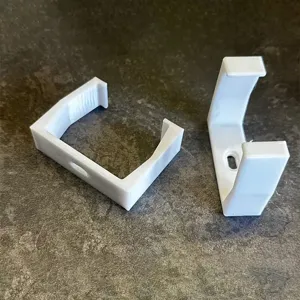 Detail view of white plastic wall mount socket bracket, punch free power strip holder tool.