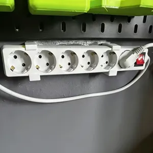 Wall-mounted power strip holder detail showing secure bracket installation on vertical surfaces.