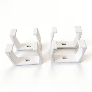 Close-up detail of white plastic mounting bracket, U-shaped cable holder slot design.