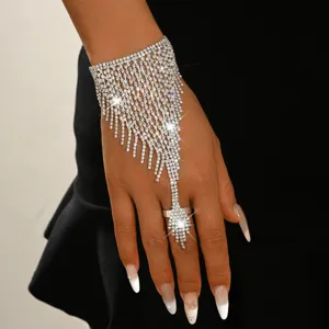 Crystal fringe finger chain detail shot, rhinestone hand bracelet, sparkly party jewelry accessory.