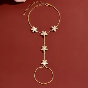 Gedetailleerd close-up van een vergulde handketting met sprankelende zirkonia bloemen.