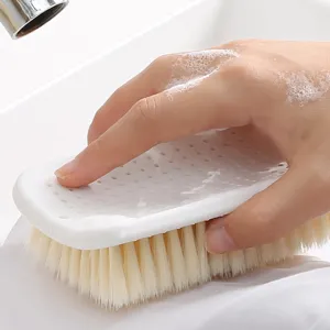 Cepillo de lavado doméstico blanco con cerdas suaves y orificios de ventilación para secar.