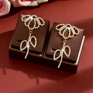 Exquisite rhinestone flower dangling earrings, detailed view showcasing sparkling crystals and bow design.