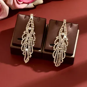 Detailed closeup of shimmering rhinestone long tassel earrings, elegant party jewelry detail.