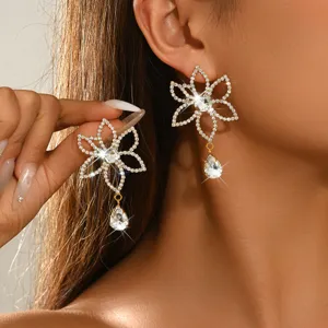 Close-up detail of sparkling rhinestone flower dangling earrings with crystal teardrop drop.