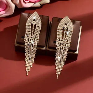 Close-up details of sparkling rhinestone long tassel earrings on display pads, shiny crystals.
