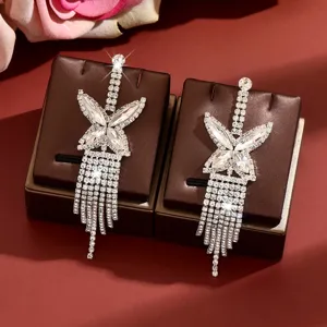 Exquisite rhinestone butterfly long tassel earrings sparkle brilliantly on brown stands.