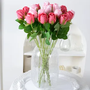 Elegant kunstmatig roze en magenta zijden rozenboeket in een glazen vaas voor decor