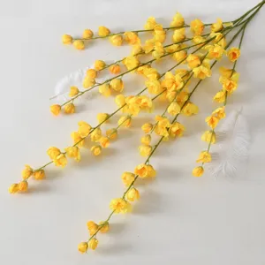 Fausse branche de delphinium jaune suspendue pour décoration murale de fête de mariage.