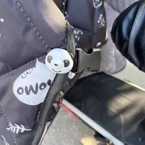 Primer plano detallado de la hebilla de protección contra el viento con diseño de panda.
