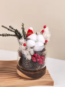 Vista dettagliata del barattolo di vetro aroma fiori secchi di Natale con pigne e batuffoli.