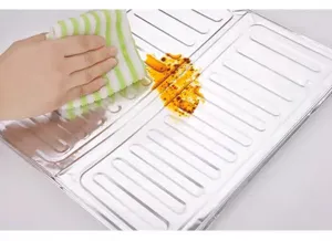 Close-up of aluminum foil stove splash guard showing easy oil stain cleaning performance.