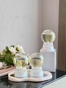Detailed view of the inverted glass globe aroma diffuser with white base, placed on tray.