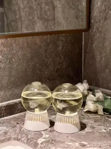 Detail view of inverted aroma diffuser glass spheres with white base and essential oil.