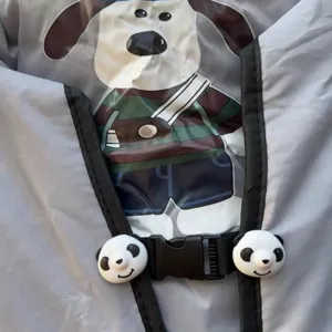 Detalle de la manta antiviento para vehículo eléctrico con diseño de perro y hebillas de panda.